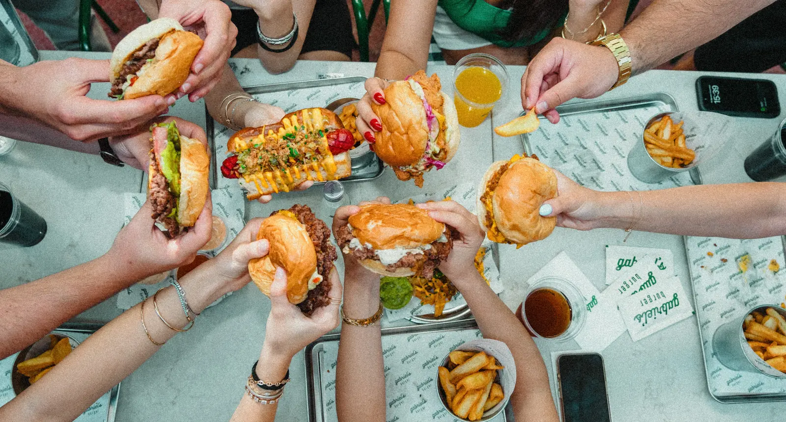Gabriel's masasında paylaşılan burgerler ve patatesler